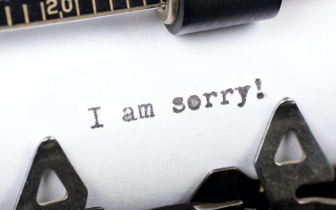 "I am sorry" typed onto a sheet of paper.