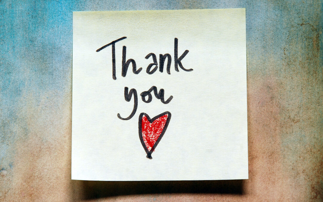 A reminder, sticky note with the handwritten words "Thank you" and a red heart.