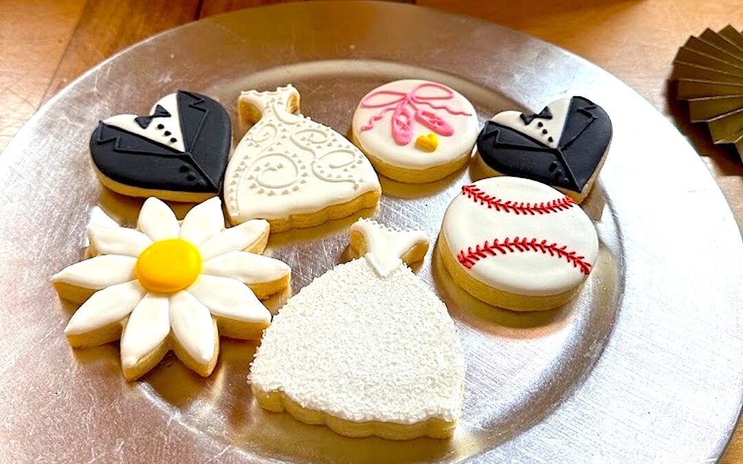 Plate of cookies decorated to look like a wedding dress, tux, baseball and dancing shoes from a special, "bonus" wedding event to celebrate with the family of the author and stepmother.
